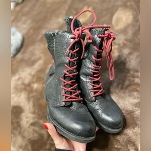 Black leather Sam Edelman combat boots with red laces up the front and back.